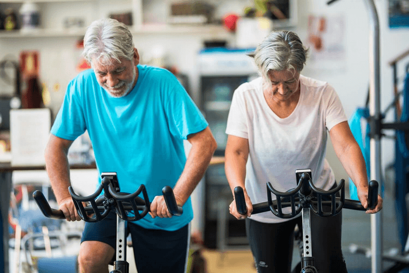 starsze małżeństwo korzysta z rowerów stacjonarnych dla seniorów