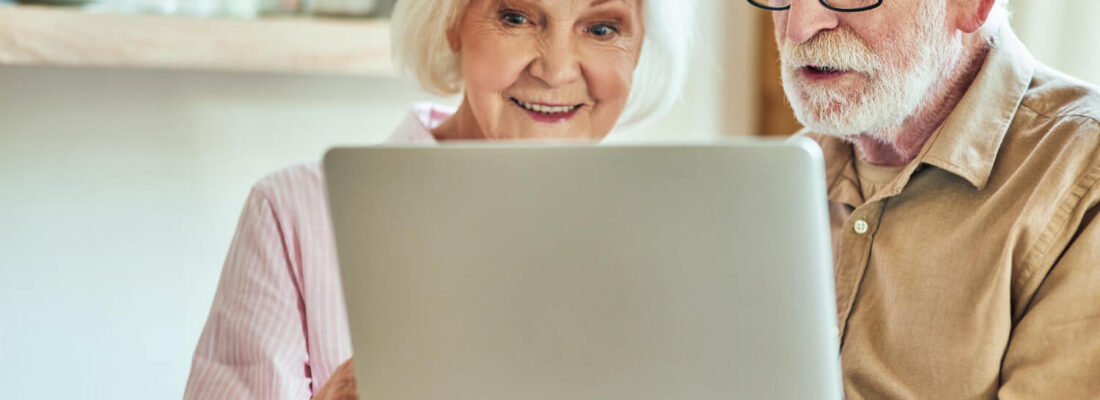 seniorzy, którzy korzystają z funkcjonalnego laptopa